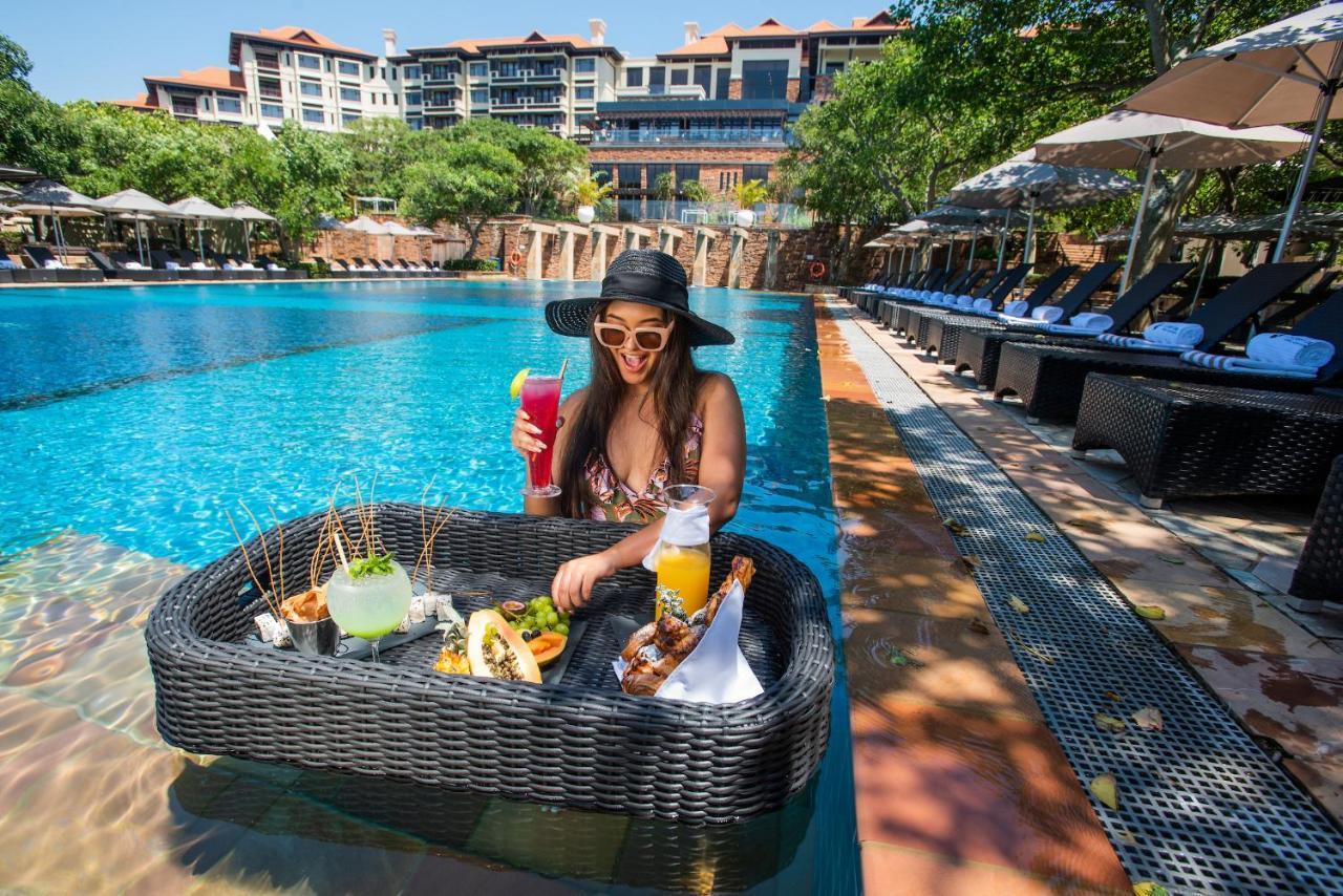 巴利托 The Capital Zimbali酒店 外观 照片 A woman at a poolside lounge